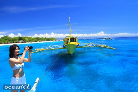 バリカサグ島の青い海とフォト派ダイバー（撮影：越智隆治）