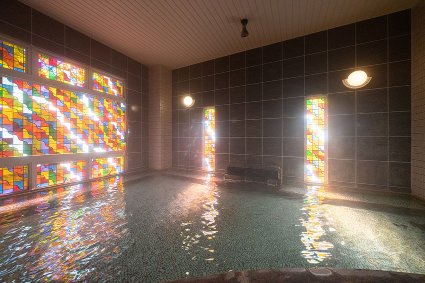 ステンドガラスが水面に反射する光景が美しいローマ風大浴場