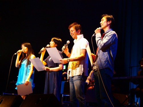 音楽とスライドに合わせて演者が朗読(左から、ドルフィンスイマーの鈴木あやのさん、女優の伊藤さやかさん、歌手・俳優の竹本孝之さん、俳優の中山夢歩さん)