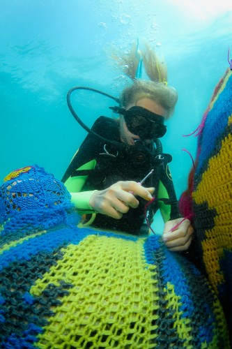 水中で編み物（クローシェ編み）をするダイバー