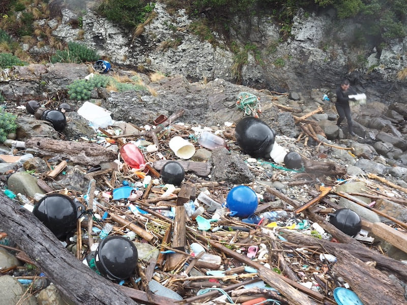 ブイなどの漁具やペットボトルなどの生活ごみで海岸は埋め尽くされている（2024年1月28日の一湊漁港周辺の海岸）