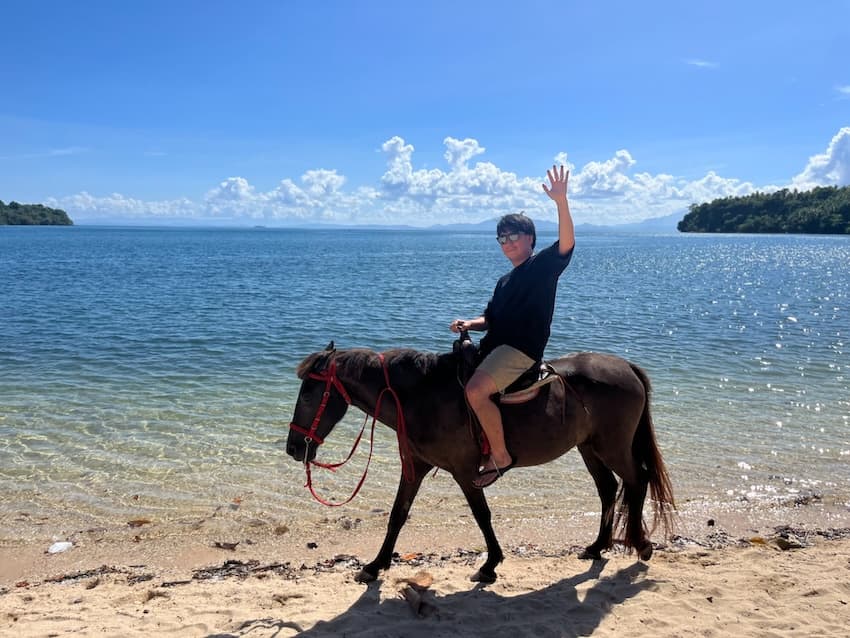 海辺での乗馬を楽しむ金床氏